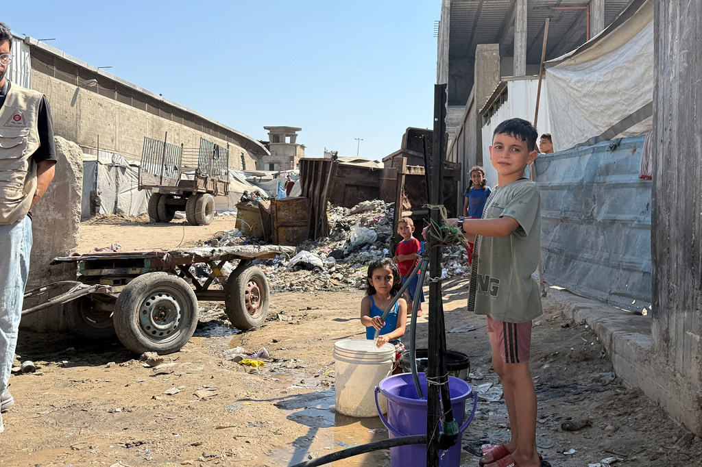 Children collect water in northern Gaza.